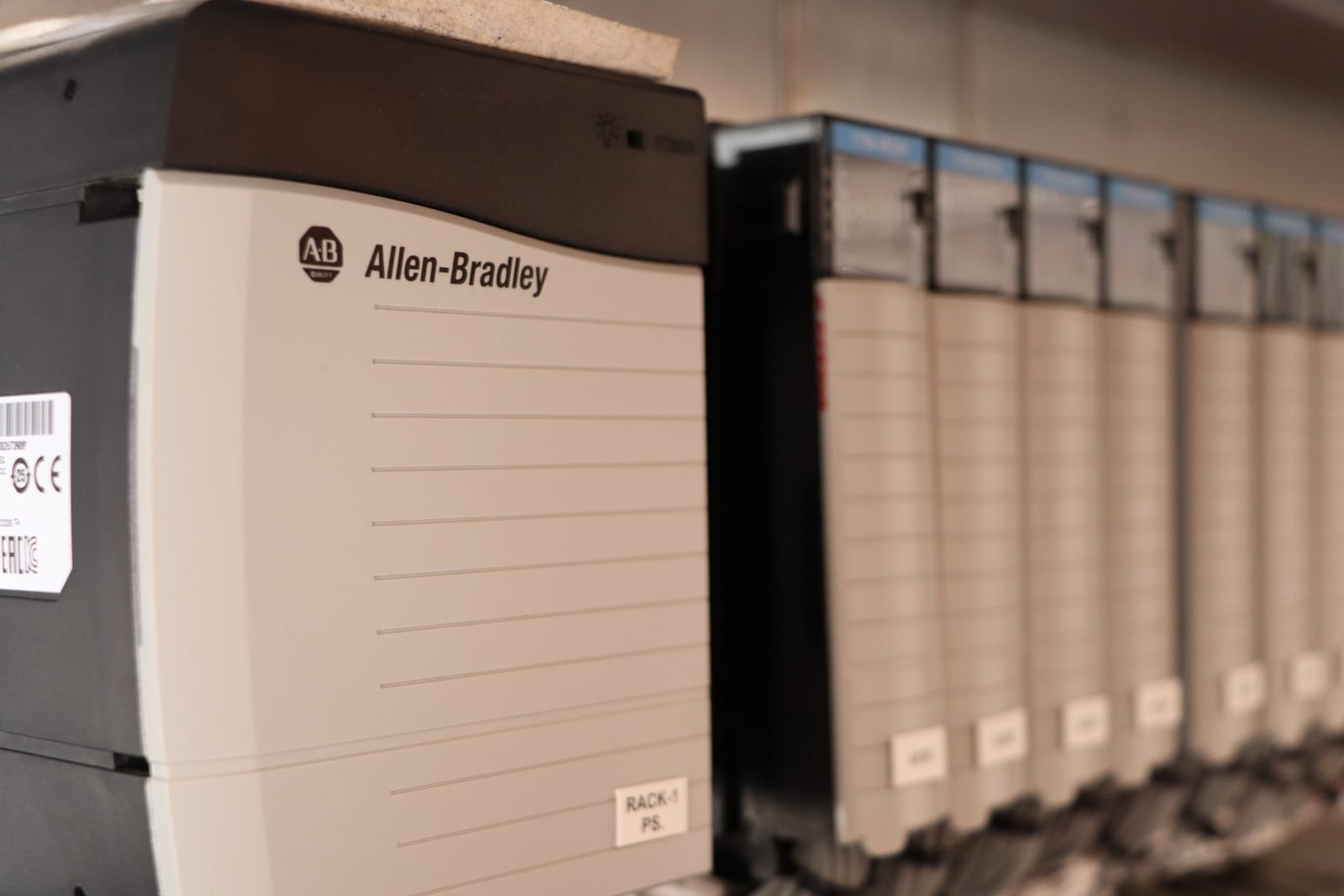 رف وحدات تحكم Allen-Bradley ووحدات الإدخال والإخراج داخل لوحة تحكم